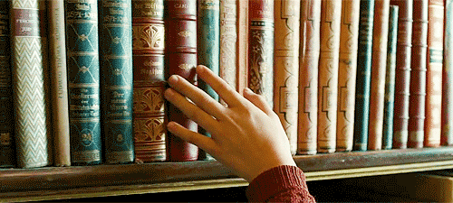 Animação de uma pessoa passando a mão pelas lombadas de vários livros