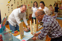 Imagem: O Diretor do Museu da Infância e do Brinquedo da UFC, Prof. Marcos Teodorico, brinca com visitantes da exposição