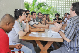 Imagem: Estudantes junto com Pró-Reitor de Assuntos Estudantes sentados ao redor de uma mesa durante reunião