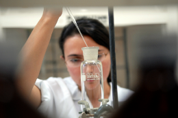 Imagem: Pesquisadora em laboratório manuseia pipeta e tubo de ensaio