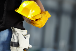 Imagem: Trabalhador segura capacete e demais equipamentos de segurança no trabalho