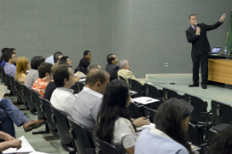 Imagem: Foto de servidores assistindo a uma palestra num auditório