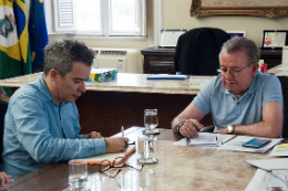 Imagem: Foto do reitor e do secretário de cultura sentados à mesa de reunião do gabinete