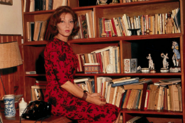Imagem: Escritora Clarice Lispector sentada ao lado de uma estante de livros (Foto: Arquivo da Família)