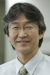 Imagem: Foto do  Prof. Osamu Ishitani, que usa óculo e camisa e gravata