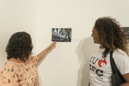 Duas mulheres olhando para uma foto em exposição no museu