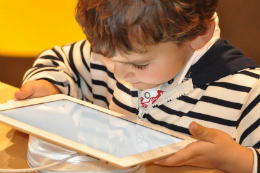 Imagem: Criança assiste a vídeo pelo tablet