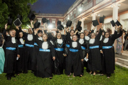 Imagem: Foto dos servidores da última turma do curso vestindo beca na coleação de grau