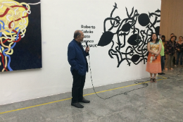 Foto do artista Roberto Galvão discursando na abertura da exposição