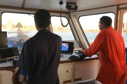 Imagem: Foto de dois homens de costas na cabine do barco do LABOMAR