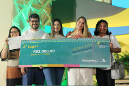 Cinco pessoas em foto posada seguram um cheque com o prêmio do segundo lugar do hackathon