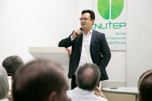 Imagem: De pé e segurando o microfone, o reitor Custódio Almeida fala aos presentes no lançamento do Programa ConecTEA