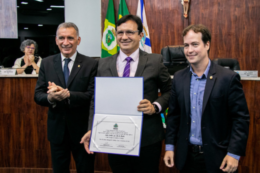 Imagem: Foto do reitor Custódio Almeida segurando a placa com o título de cidadão de Fortaleza