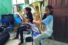 Duas meninas estudantes tocando instrumentos de sopro