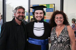 Foto de Yago da Cruz, vestido de beca, ao lado dos pais
