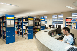 Imagem: foto da biblioteca do campus de Quixadá com bibliotecário sentado atrás de um balcão