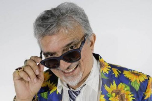 Imagem: foto do humorista Falcão. Ele está segurando os óculos escuros no rosto, mostrando um pouco dos olhos