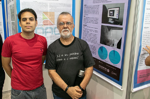 Imagem: servidor técnico-administrativo Hermany Rosa Vieira ao lado de um estudante