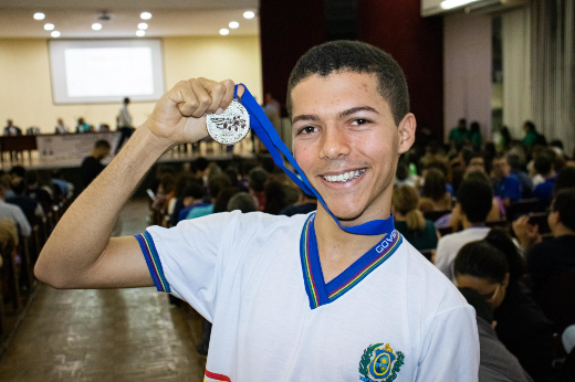 Imagem: estudante do ensino médio mostra medalha