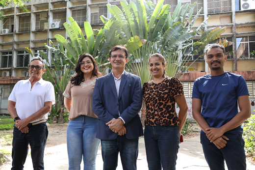 Imagem: Da esquerda para a direita, em um jardim, posam de pé: Fernando Henrique Monteiro, Caroline Lima, reitor Custódio Almeida, Adriana Costa e Igor Bruno