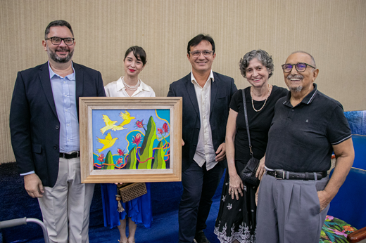 Imagem: De pé, da esquerda para a direita: Prof. Cavalcante Junior (diretor da Editora UFC); Profª Juliana Diniz (vice-diretora, segurando nas mãos o quadro que estampa a capa do livro); Prof. Custódio Almeida (reitor); Lúcia Helena Galvão (esposa do artista) e Roberto Galvão (artista que assina o quadro). (Foto: Ribamar Neto/ UFC Informa)