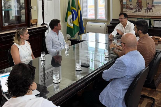 Imagem: Participantes da reunião sentados à mesa