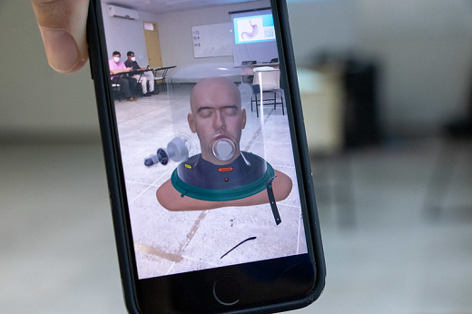 Imagem mostra celular em que aparece na tela a simulação da cabeça de uma pessoa utilizando capacete Elmo, utilizado para respiração assistida