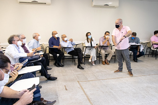 Imagem mostra parte dos professores que acompanharam a apresentação, que estão sentados em sala de aula com cadeiras distribuídas em formato de círculo