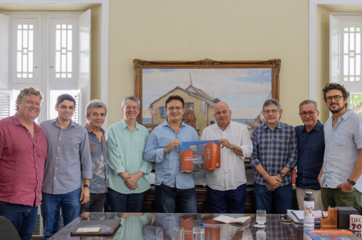 Empresários posando para a foto, reunidos com o reitor ao redor da mesa da Reitoria