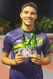 Imagem: foto do atleta Lucas Lisboa, do Curso de Educação Física, mostrando as medalhas penduradas no pescoço
