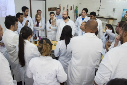 Imagem: Pessoas vestidas com jaleco branco tendo aula em uma sala fechada (Foto: Ribamar Neto/UFC)