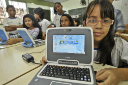 Imagem: Criança mostra laptop doado pelo projeto Um Computador por Aluno, por meio do qual objetos de aprendizagem são usados na prática pedagógica (Foto: Marcello Casal Jr./ABr)