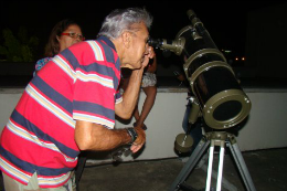 Imagem: Homem observando o céu através de telescópio