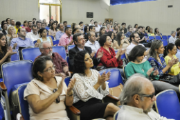 Imagem: Servidores sentados em cadeiras do auditório durante cerimômia de posse