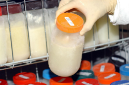 Imagem: Frasco de vidro com leite humano saindo de refrigerador hospitalar