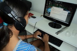 Foto de uma mulher mexendo no computador com fones de ouvido (Foto: prolu.wordpress.com)