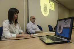 Imagem: Foto da Profª Ruth Pinho e do Prof. Almir Bittencourt à mesa do seminário