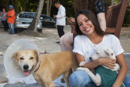 Imagem: Foto da aluna Thaise com um cachorro no Campus do Pici