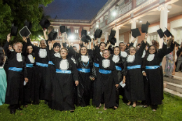 Imagem: Turma de servidores vestidos de beca nos jardins da reitoria da UFC