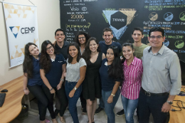 Imagem: Foto dos alunos integrante do CEMP junto ao prof. Abraão na sala do projeto, onde se vê paredes pretas com desenhos diversos