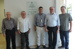 Imagem: foto de cinco homens em pé sorrindo ao lado da placa de inauguração