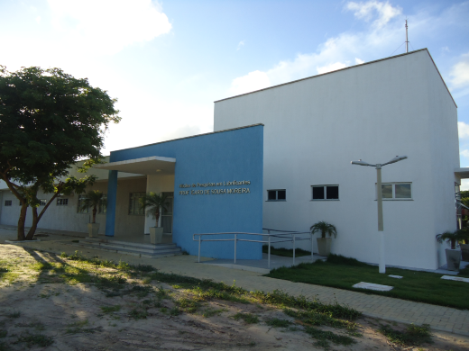 Foto da fachada do Núcleo de Pesquisas em Biolubrificantes da UFC, que é um prédio térreo branco com uma entrada azul