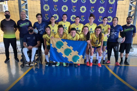 Foto posada do time de futsal feminino da UFC ao lado da comissão técnica 