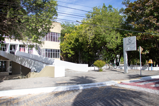 Imagem: Foto da entrada da Biblioteca Central do Campus do Pici com uma passarela de concreto