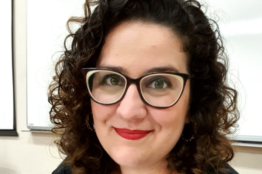 Foto da pesquisadora Carla Barreto com cabelos cacheados e usando um par de óculos