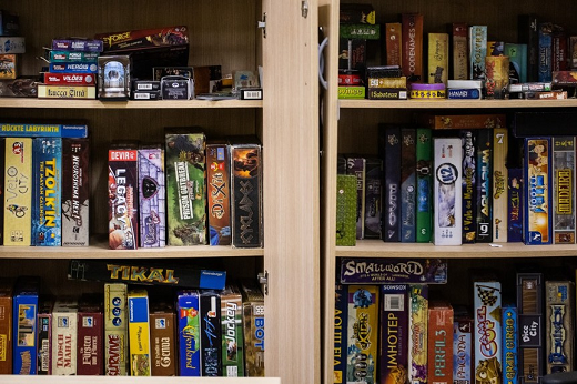 Imagem: foto de uma estante com vários jogos de tabuleiro