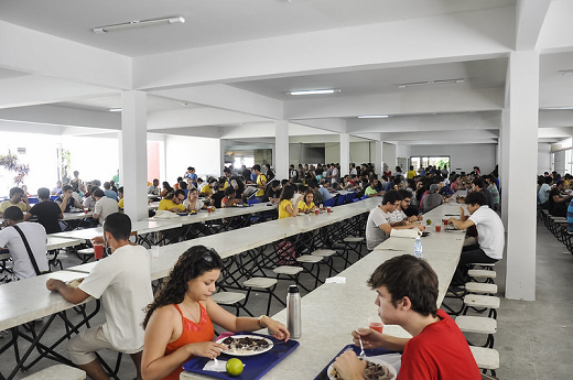 imagem: foto de um refeitório com pessoas se alimentando