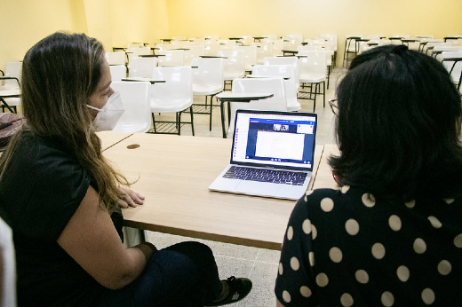 Imagem: Foto das professoras Nila Bandeira e Cátia Silva acompanhando a webconferência da disciplina de Projeto Integrado I