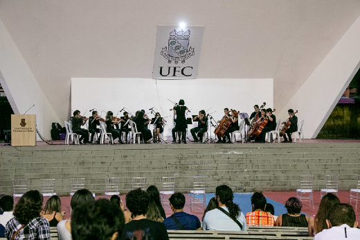 Imagem: Foto da Camerata de Cordas da UFC tocando no palco da Concha Acústica