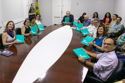 Imagem: Foto do evento de lançamento do Anuário Estatístico e do Relatório de Gestão, com o reitor e os pró-reitores segurando livros com capa de cor verde